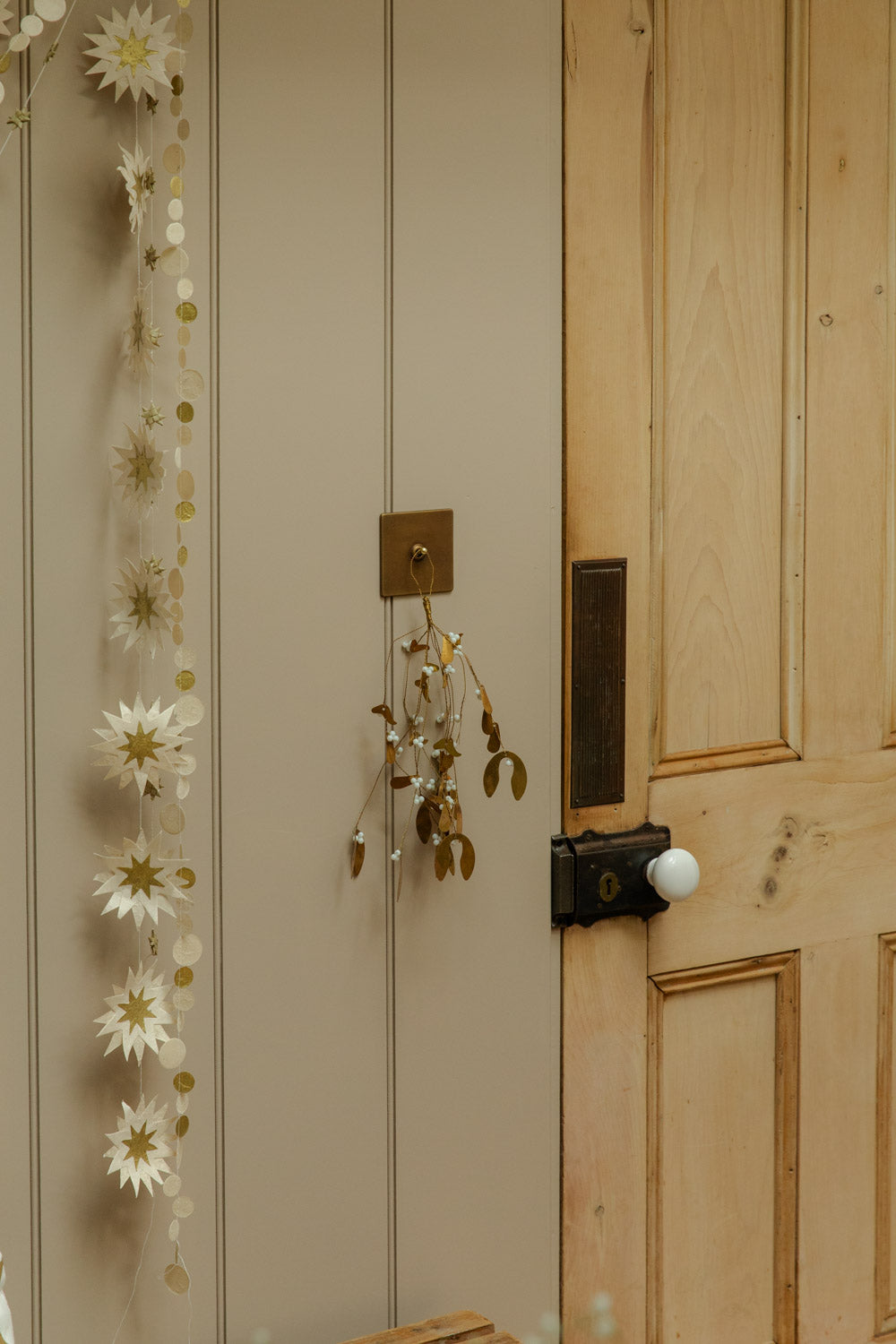 Decorative floral garland on a wooden door with a neutral wall background