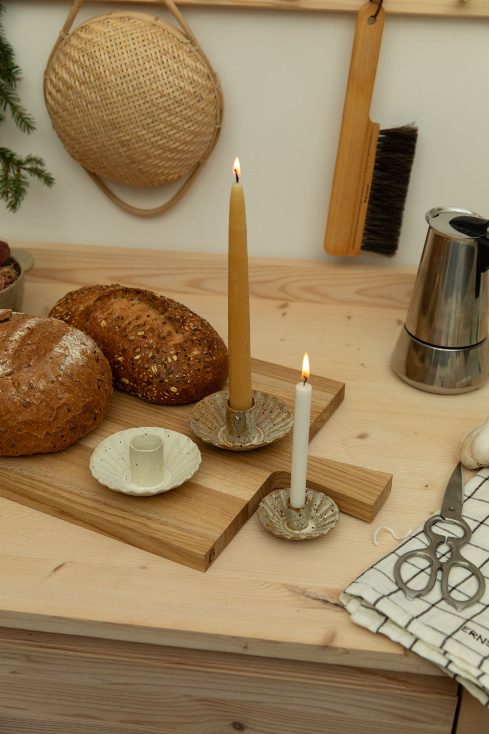 kitchen worktop with wooden board, loaves of bread, candle holders and more.