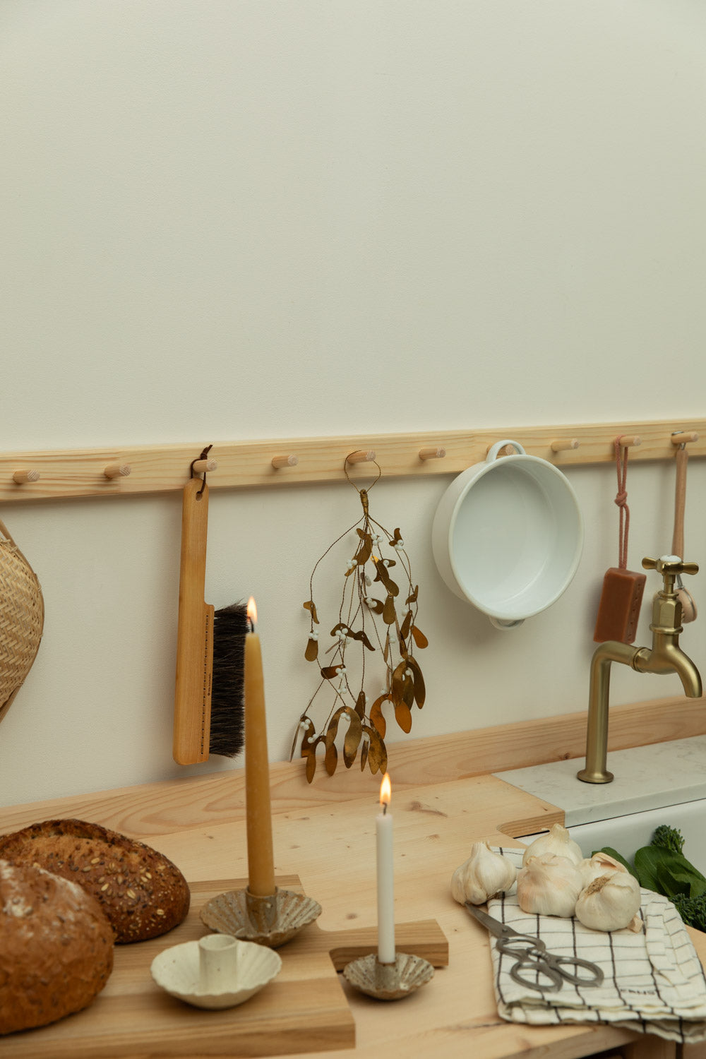 Kitchen counter with bread, candles, and a sink with a gold faucet.