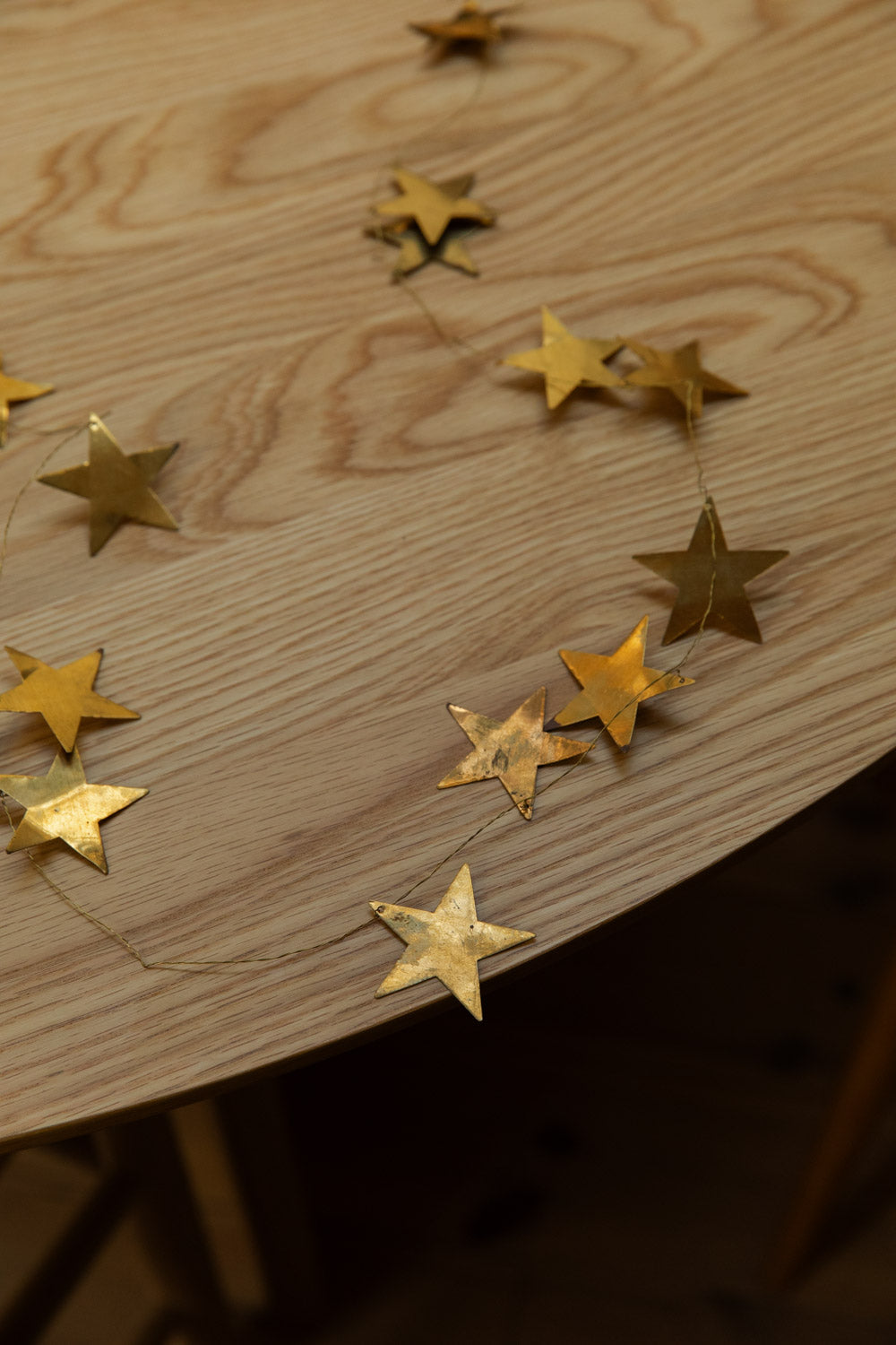 Gold star-shaped decorative garland on a wooden surface