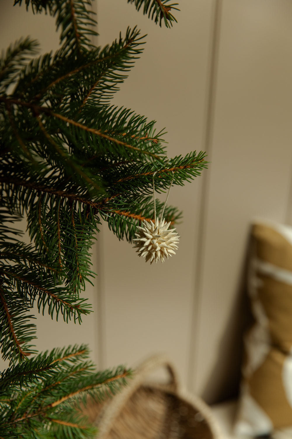 Close-up of a Christmas tree branch with a blurred gift box in the background