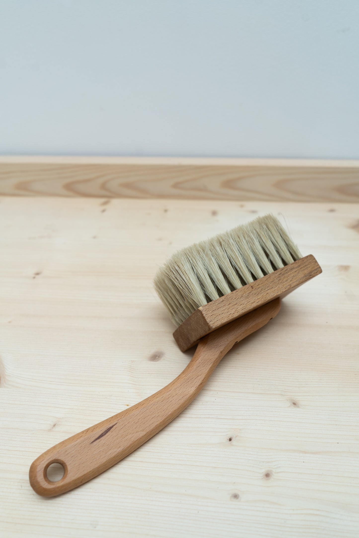 Wooden brush with bristles on a wooden surface