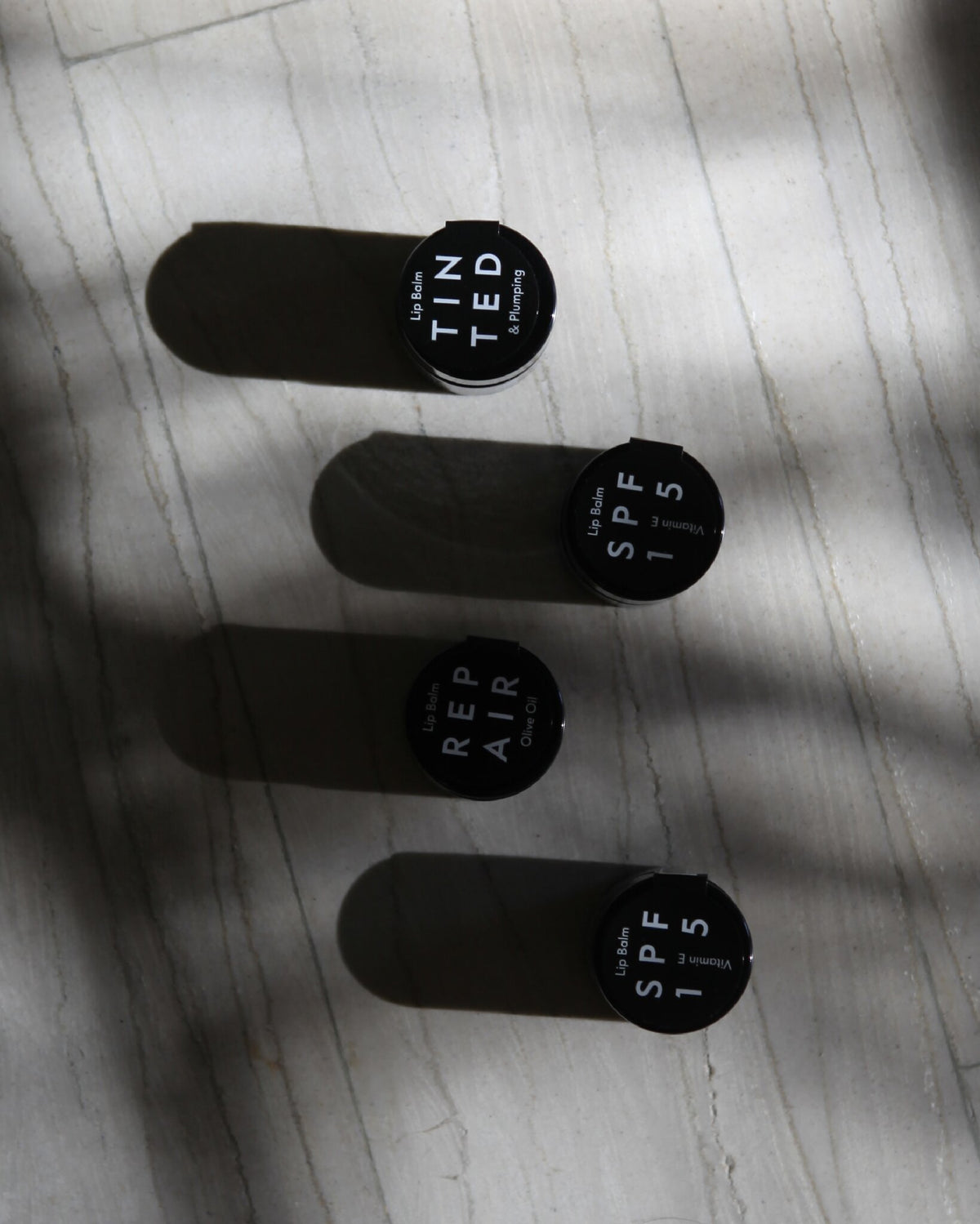 Aeolis lip balm jars laid out in light and shadow