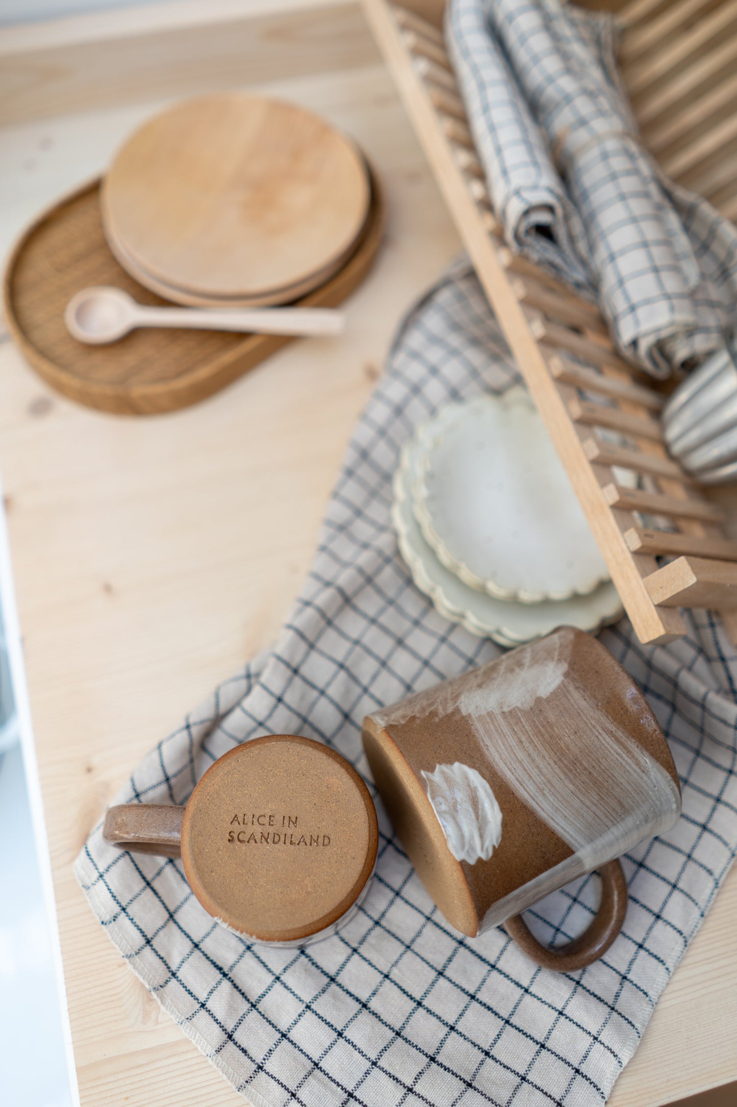 Stoneware mugs with decorative elements on a checkered cloth