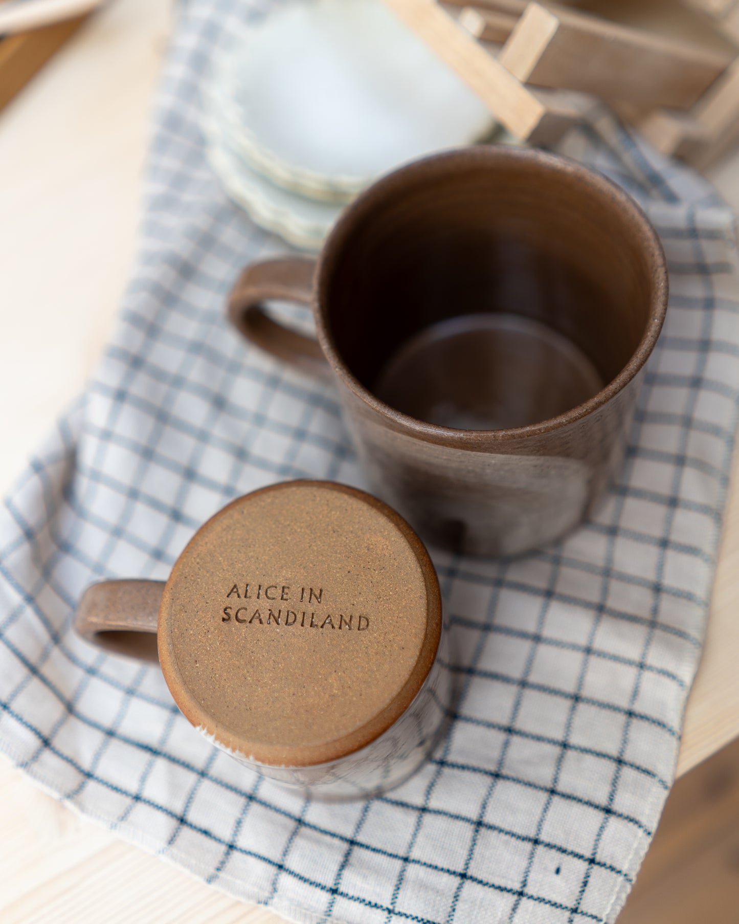 Brown ceramic mug on a checkered cloth