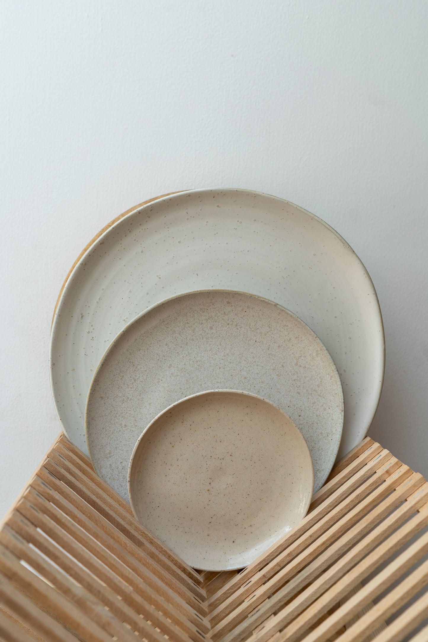 Two ceramic bowls stacked on a wooden surface with a light gray background