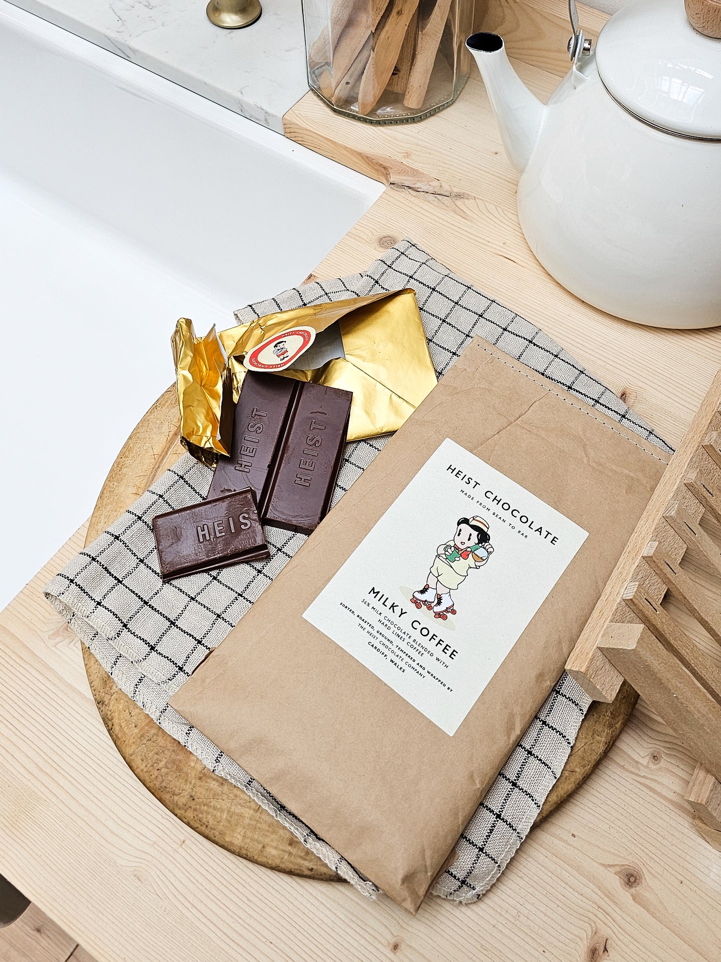Heist chocolate bars on a wooden surface with a tea set in the background