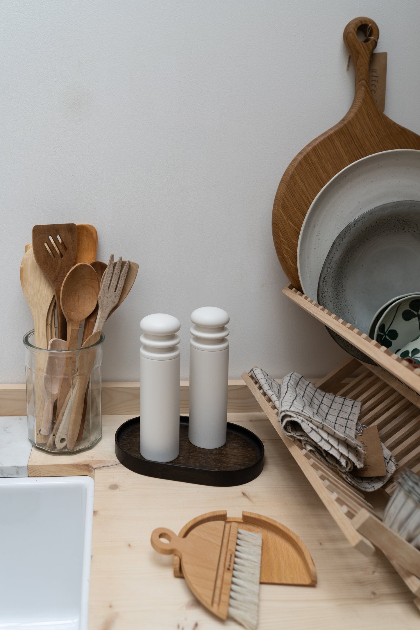 Kitchen counter with wooden utensils, salt and pepper shakers, and a cutting board.