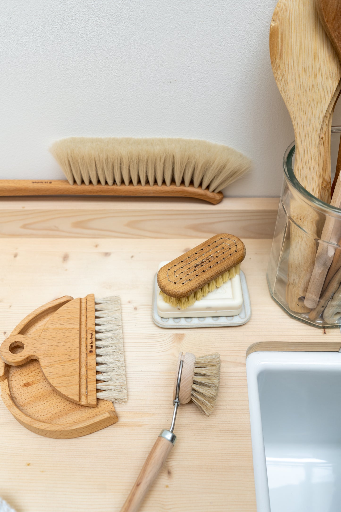 Set of cleaning brushes and tools on a wooden surface.