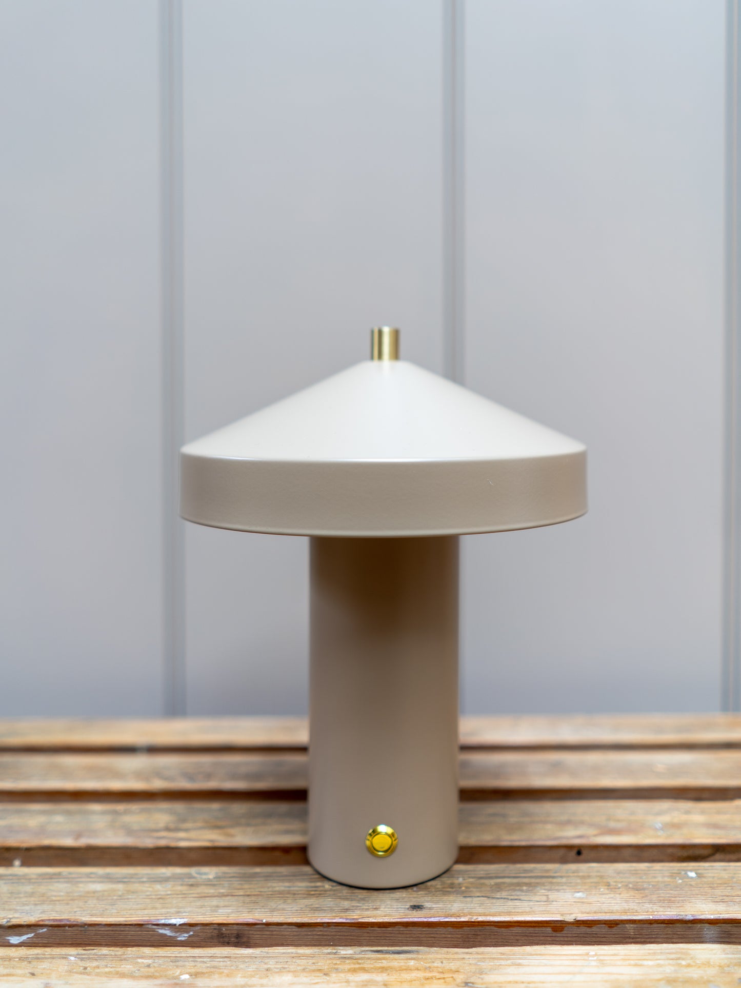 Beige table lamp on a wooden surface with a light gray background