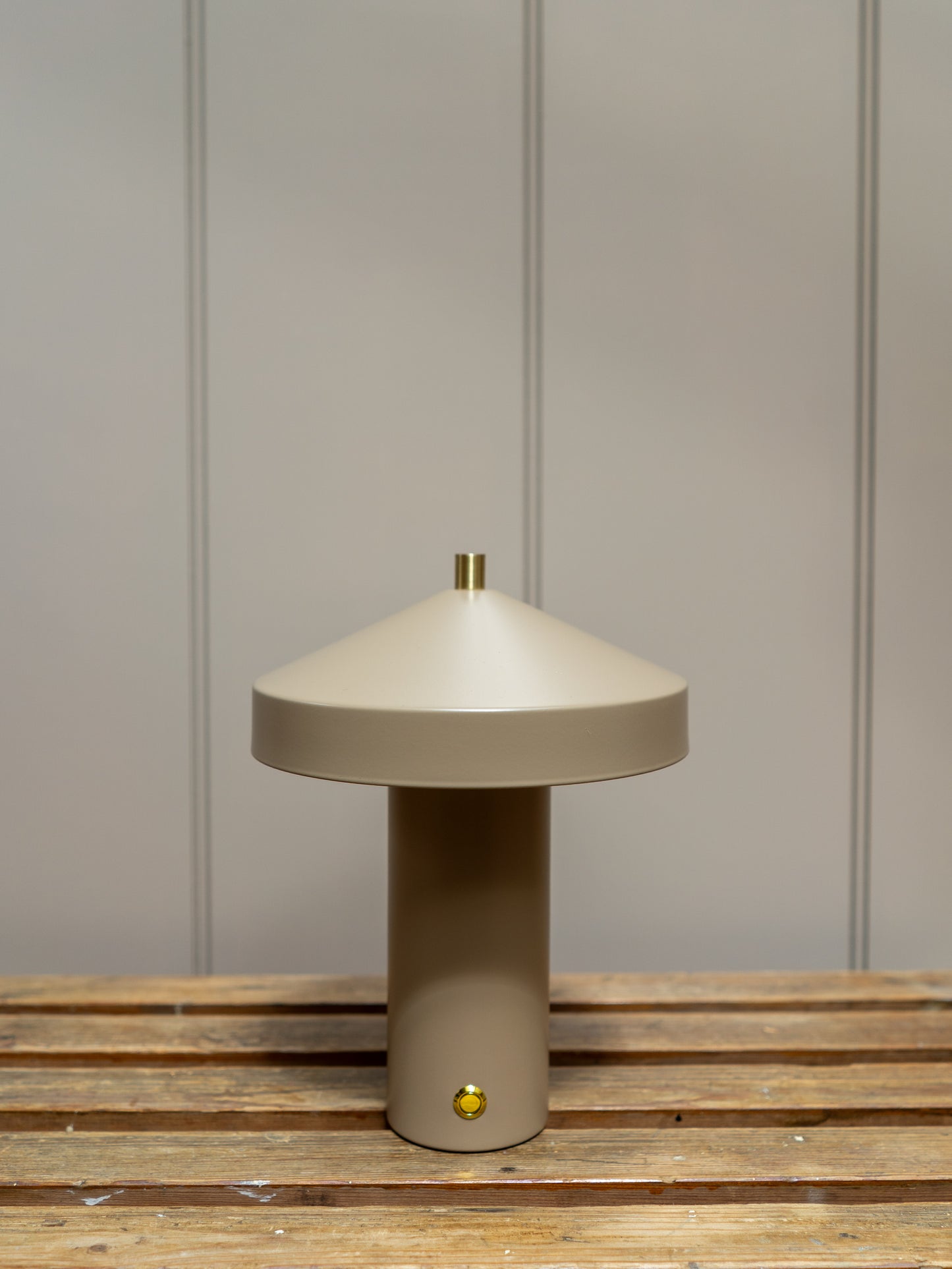 Beige table lamp on a wooden surface with a neutral wall background