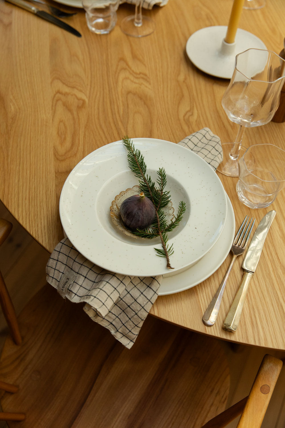 Dinner setting with a plate of food on a wooden table.