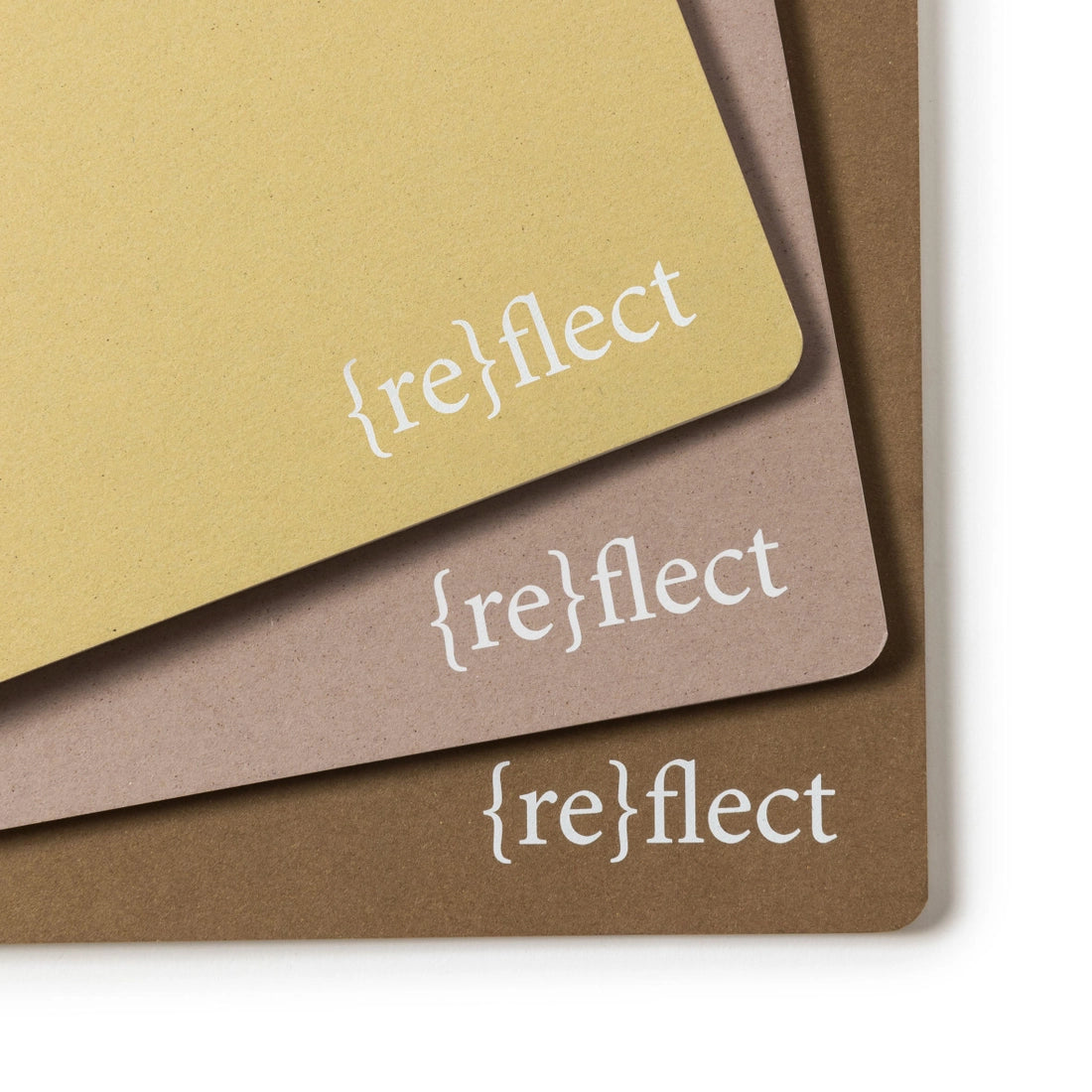 A close up of three notebooks stacked on a white background.