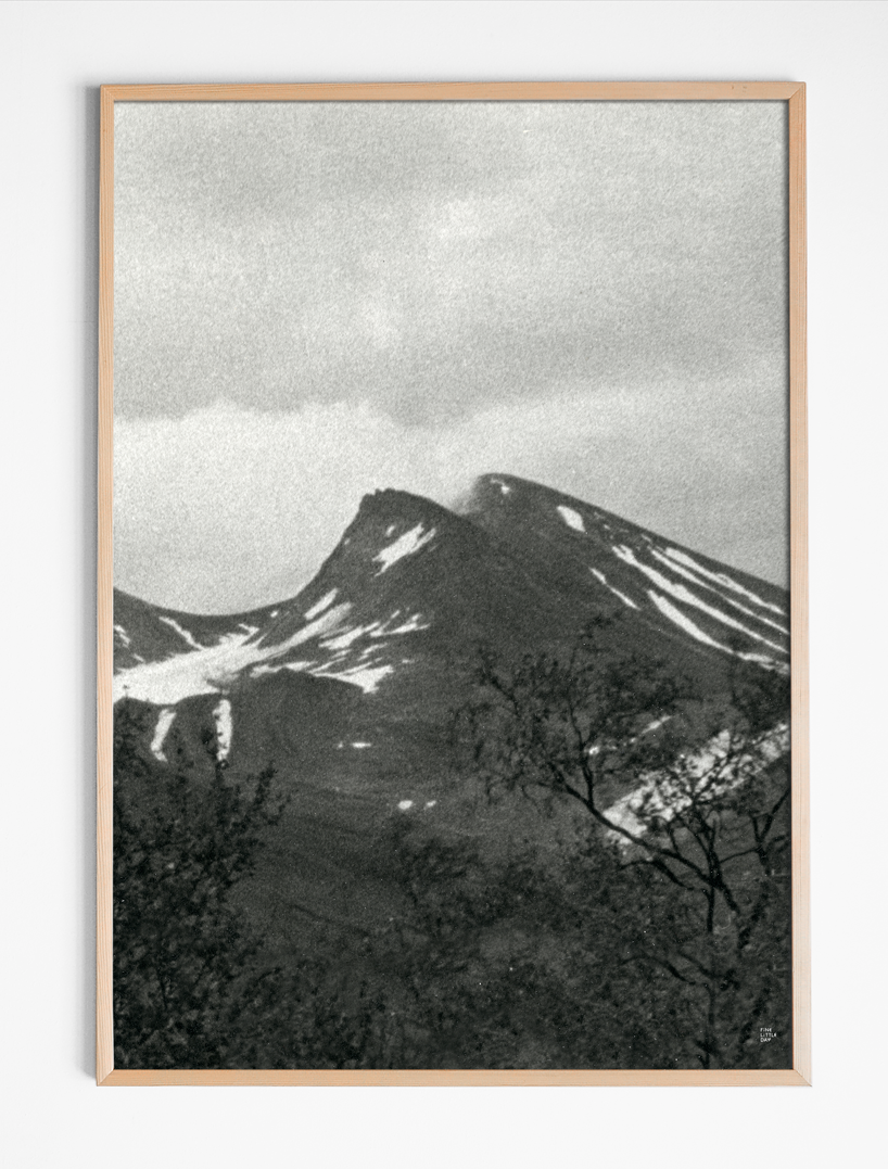 Framed black and white mountain landscape print on a white wall.