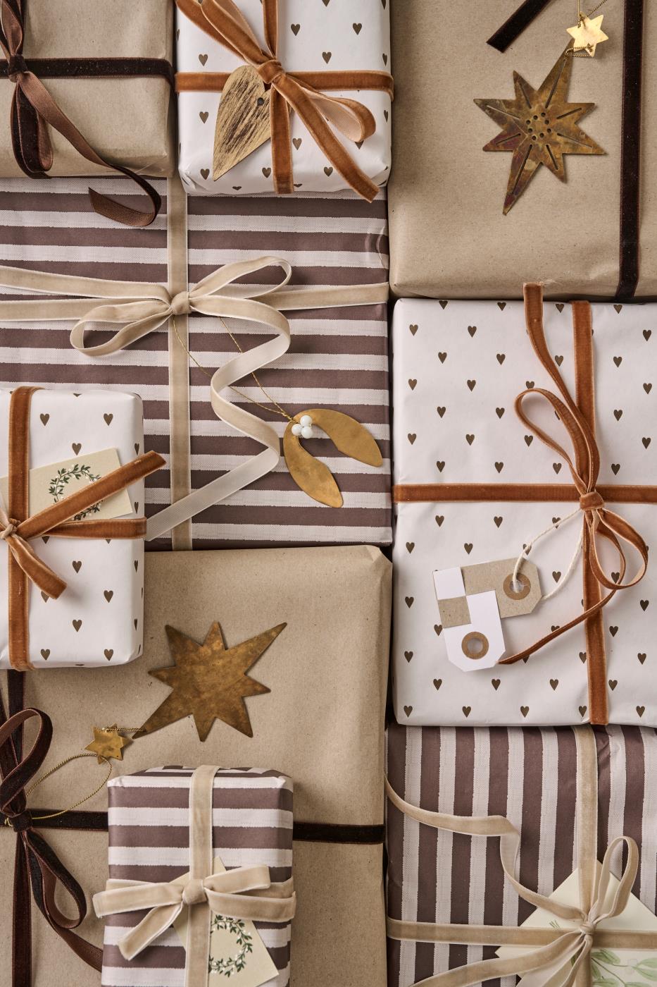 Collection of gift boxes wrapped in brown, beige, and white paper with ribbons and stars.