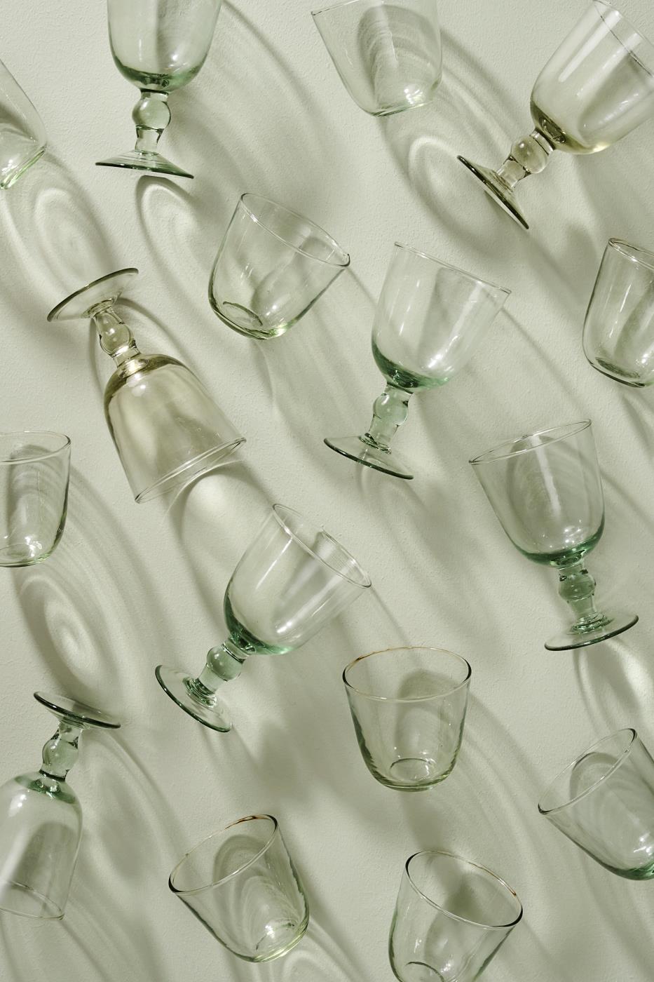 Clear glassware arranged on a light green background