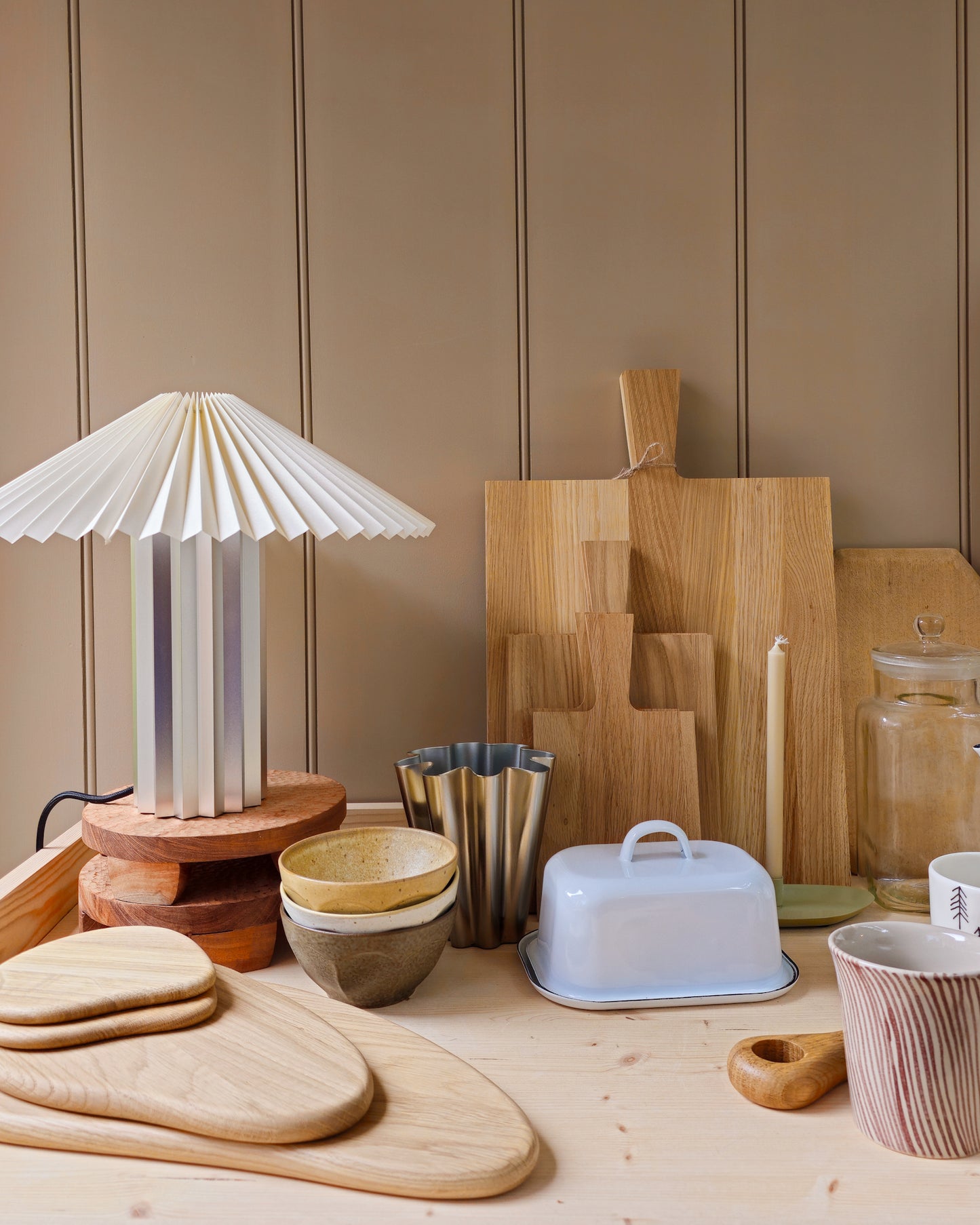 Collection of wooden chopping boards and Blomus Taite lamp in lily white in a kitchen setting.