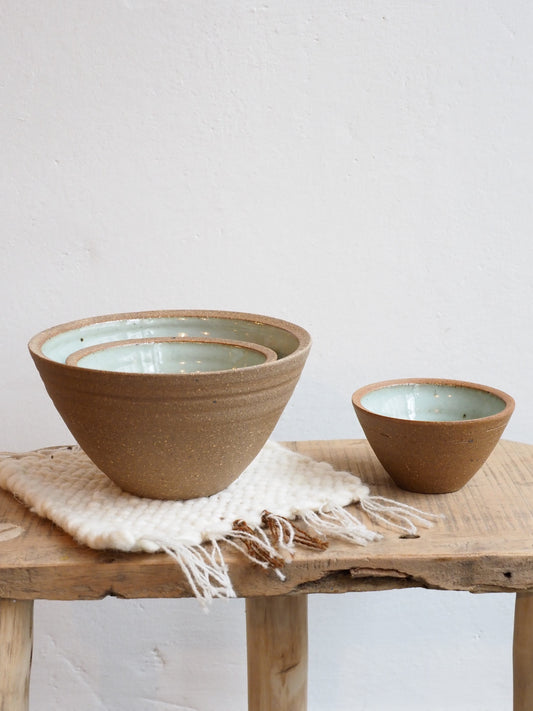 Three ceramic prepping bowls with Chun glaze inside, one large and one small, displayed on a wooden surface.