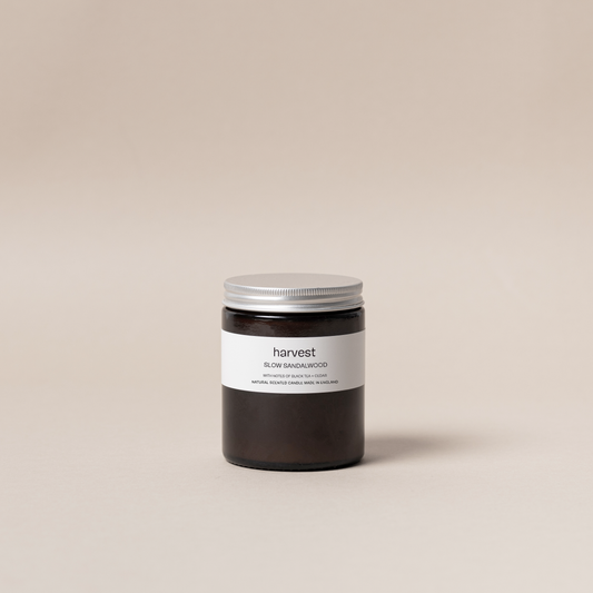 Harvest Slow Sandalwood candle in amber glass jar with silver lid