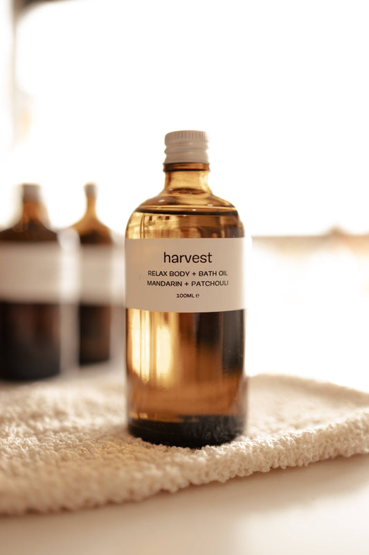 Harvest Relax Body and Bath Oil 100ml amber bottle on textured white cloth