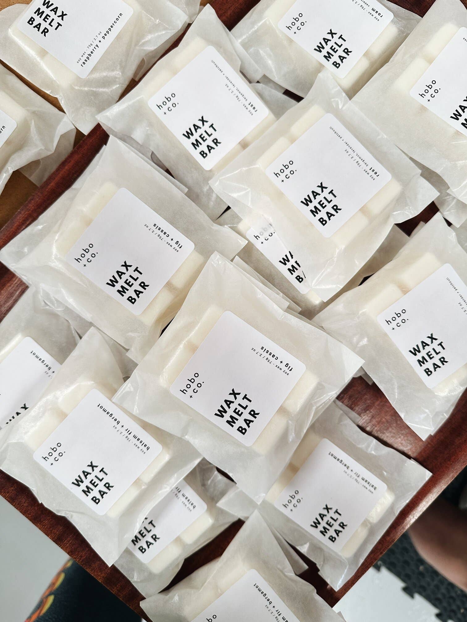 Multiple wax melt bars with labels on a wooden surface