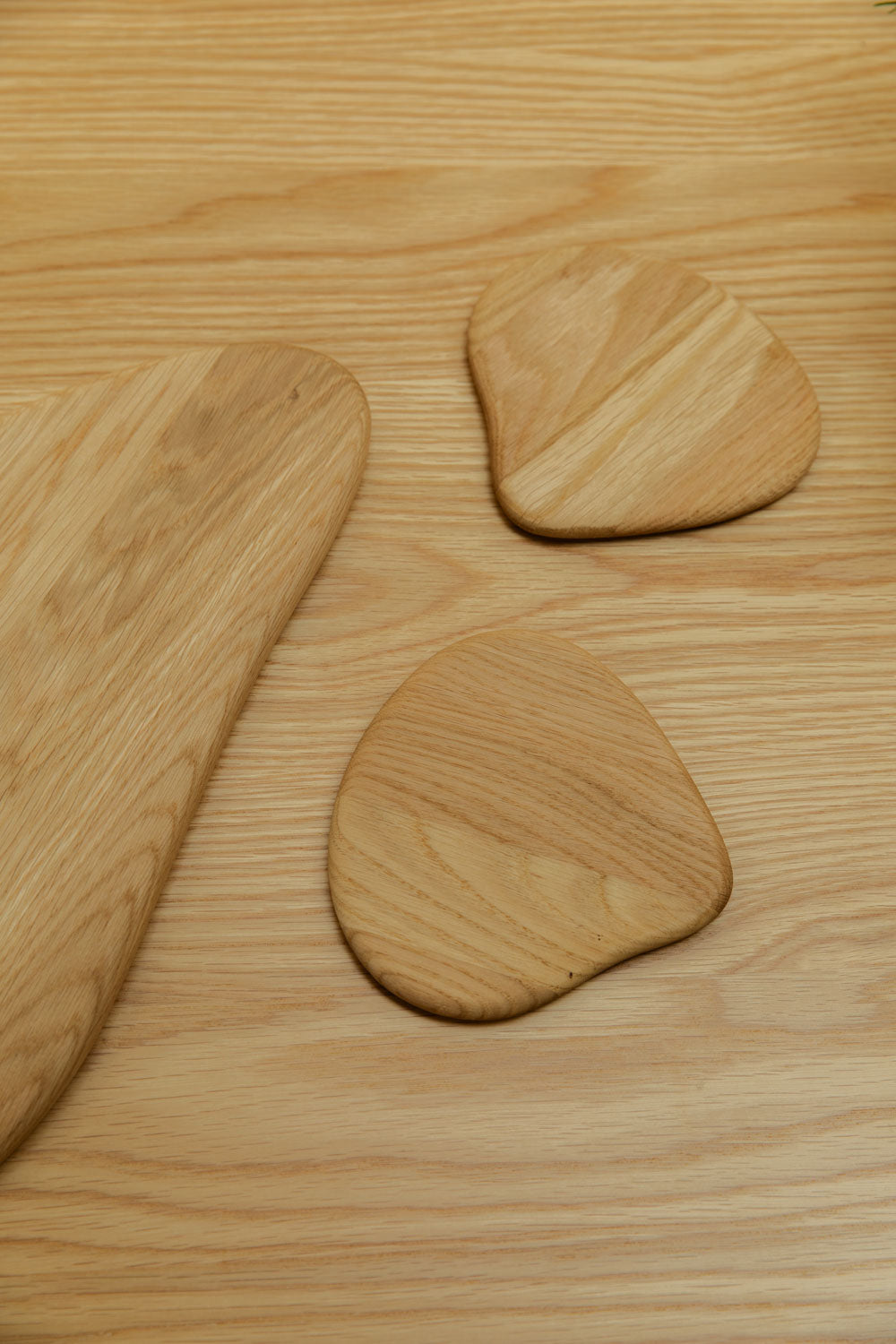 Three wooden boards/coasters on a wooden surface