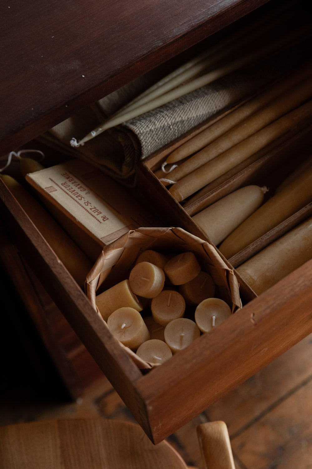Wooden drawer with candles and other items on a wooden floor
