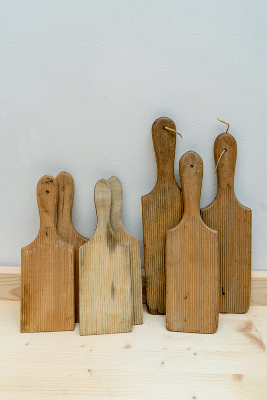 Set of wooden butter pats on a light wooden surface with a light gray background