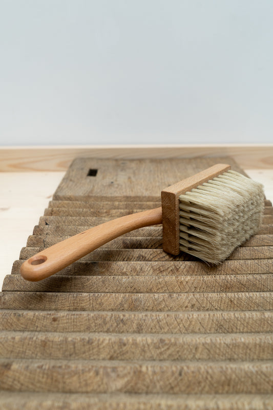 Wooden brush with bristle head on a wooden surface