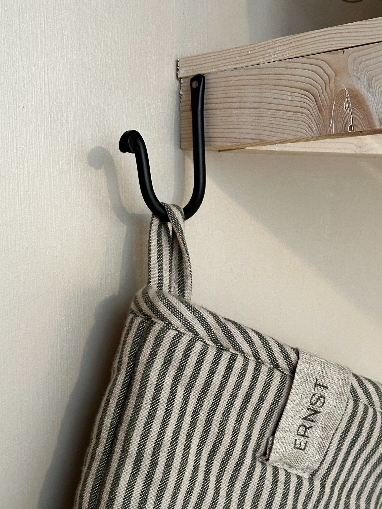 Strömshaga simple black iron hook 9cm mounted on wooden shelf with striped linen oven glove