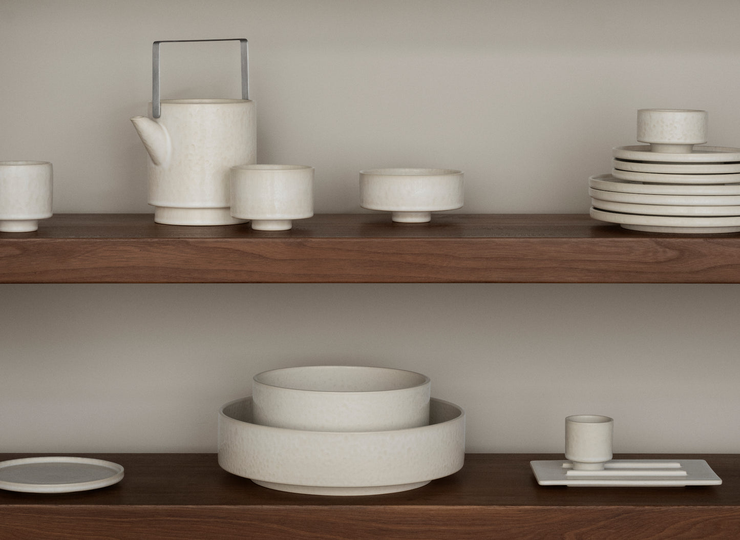 Set of ceramic dishes on wooden shelves against a neutral background