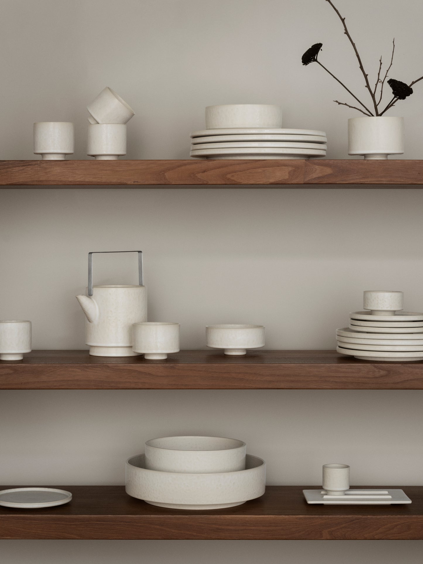 Wooden shelves with ceramic dishes and a minimalistic decor style.