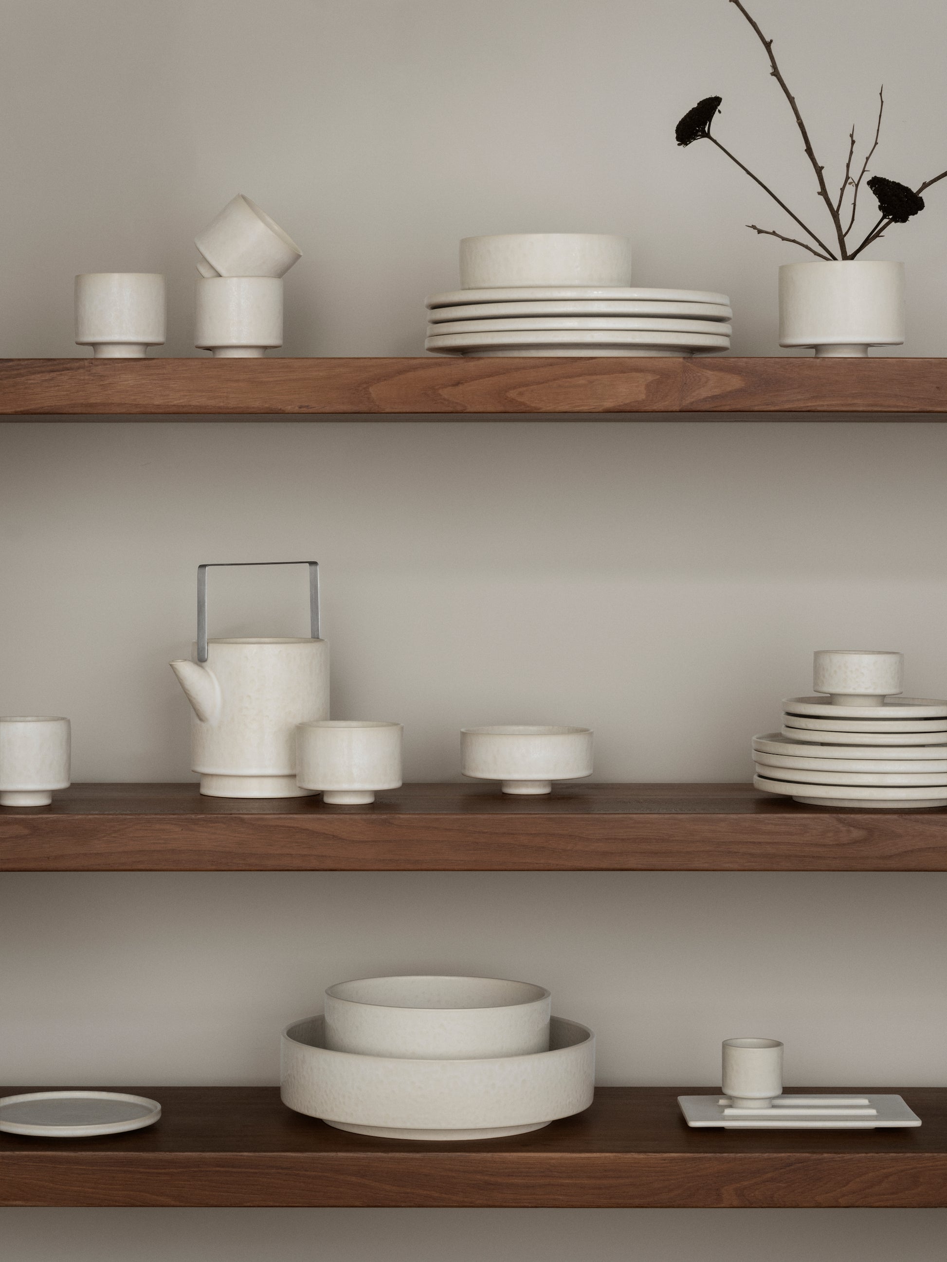 Wooden shelves with ceramic dishes and a minimalistic decor style.