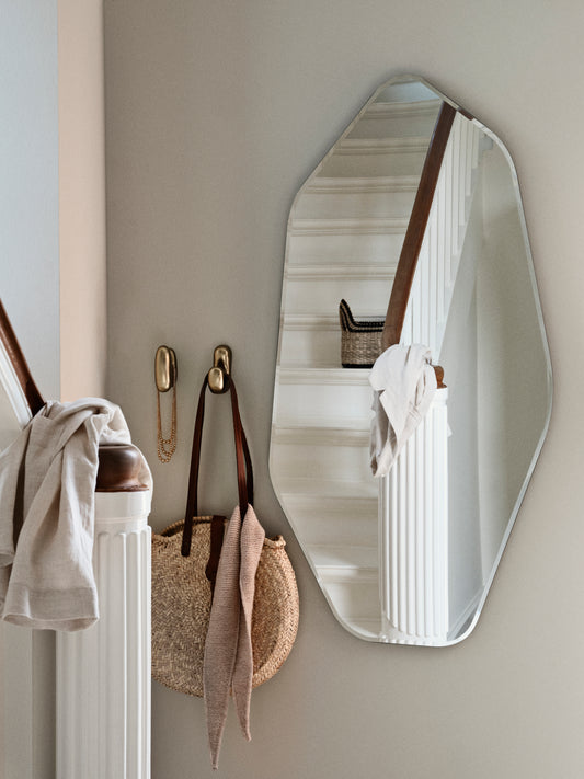 Wall mirror with a neutral color scheme in a room setting