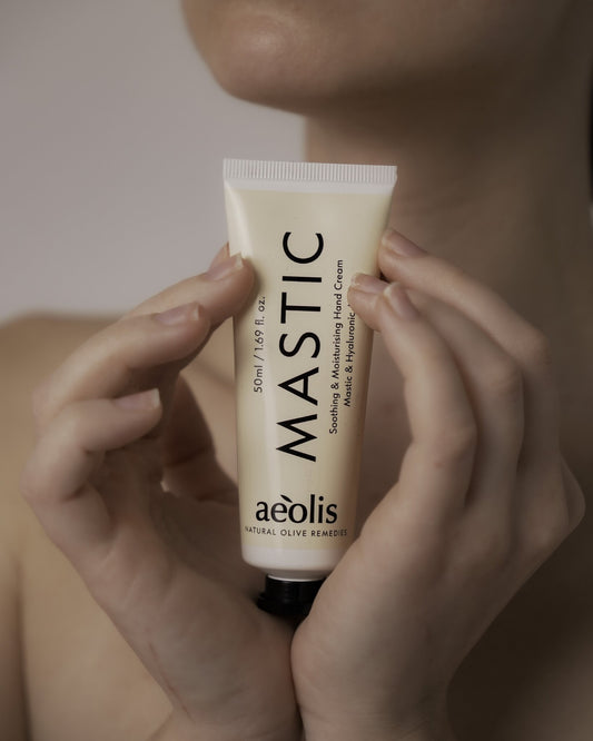 Hands holding a tube of Aeolis mastic hand cream