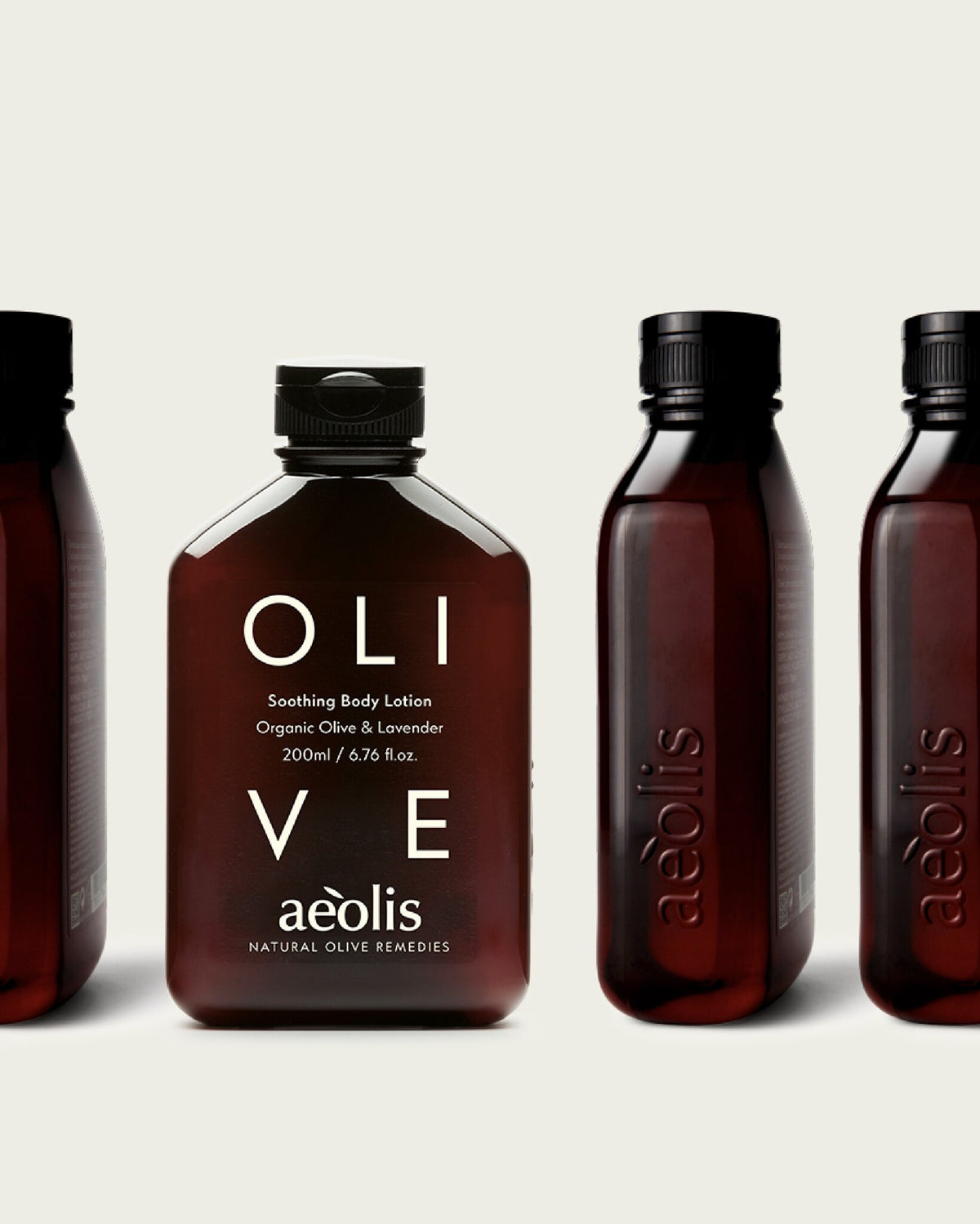 Aeolis olive and lavender body lotion beside other amber bottles