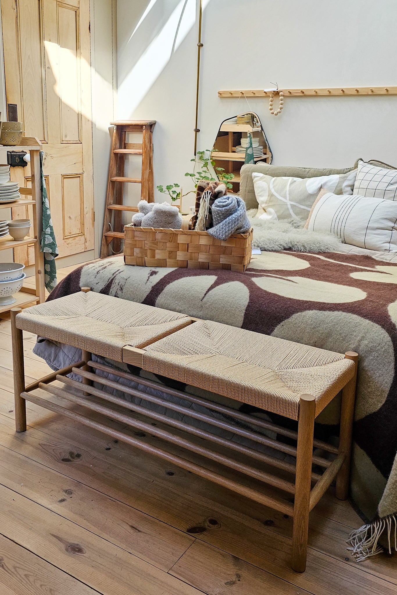 Longworth Bench in solid oak with woven papercord seat, styled at the foot of a bed with wool throw and basket