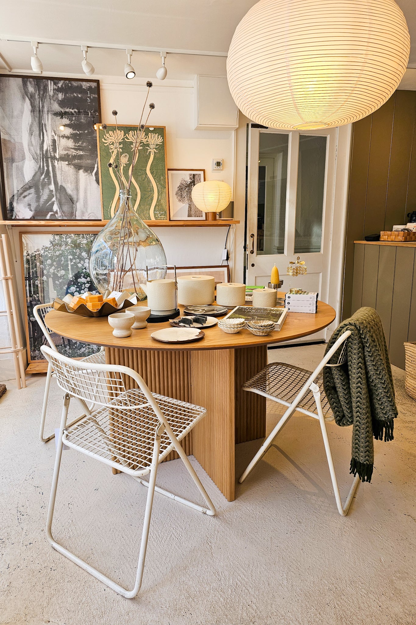 Dining area with a wooden table and white chairs in a modern interior setting.