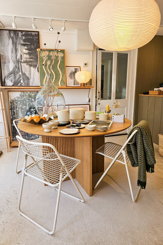 Dining area with a wooden table and white chairs in a modern interior setting.