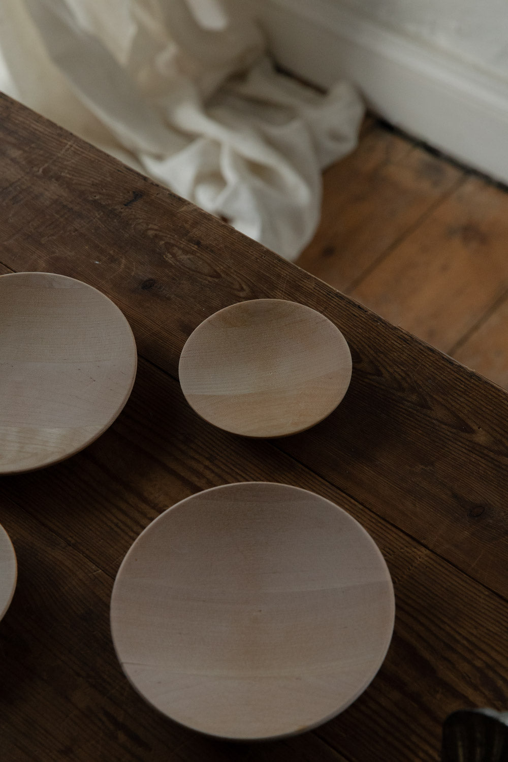 Three Birch wood bowls on a rustic wooden surface with a blurred background.