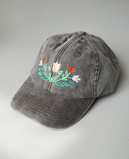 Gray black cap with floral embroidery on a light gray background