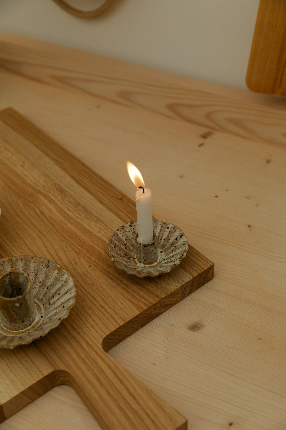 Candle in a decorative holder on a wooden surface.