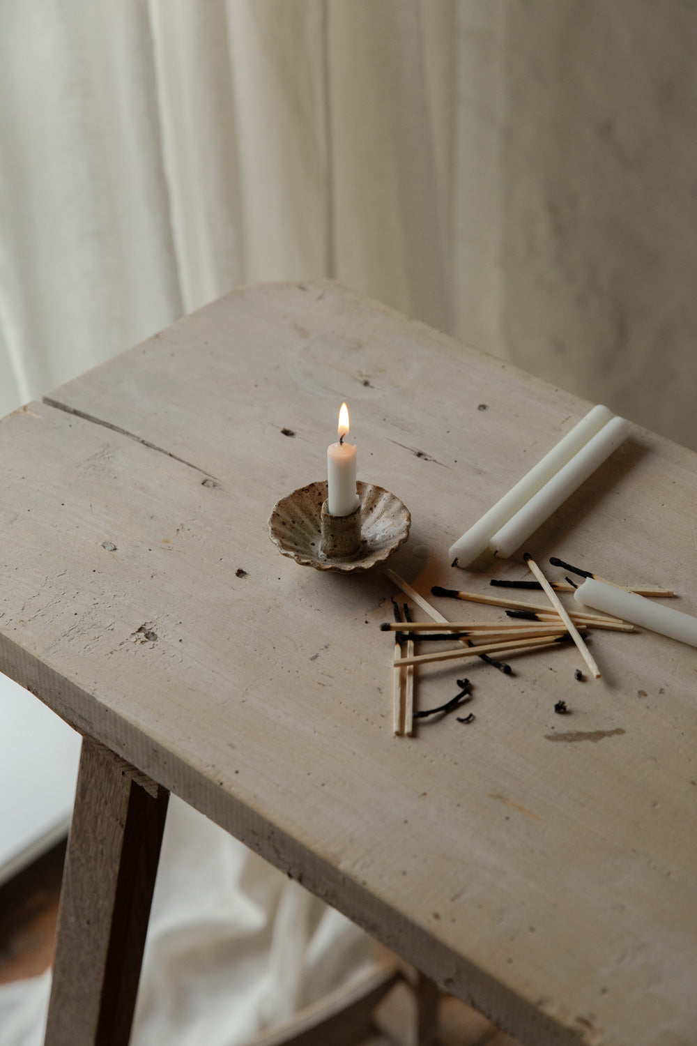 Candle and matches on a wooden table with a blurred background.