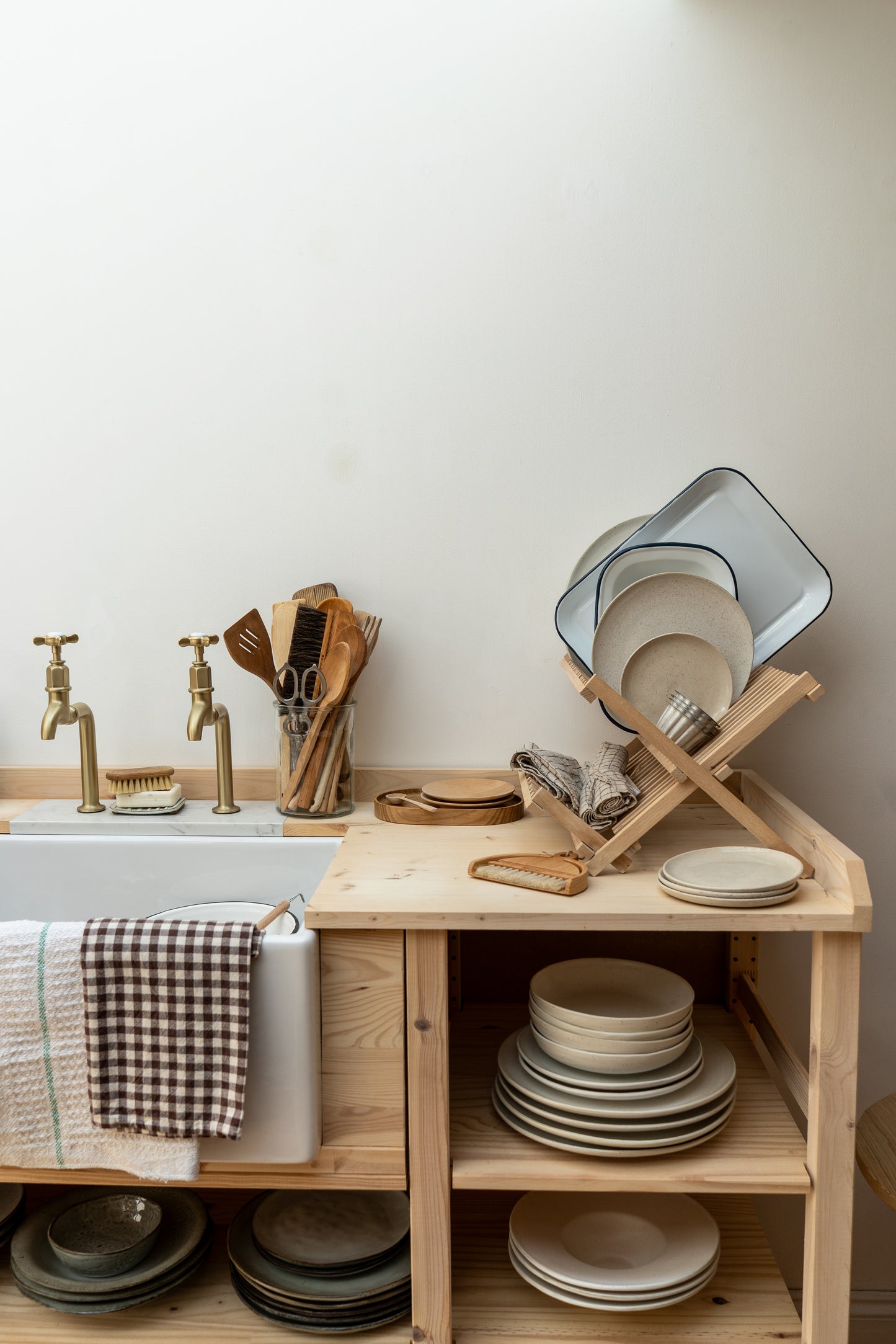 Kitchen setup with wooden shelf, sink, and various dishes.