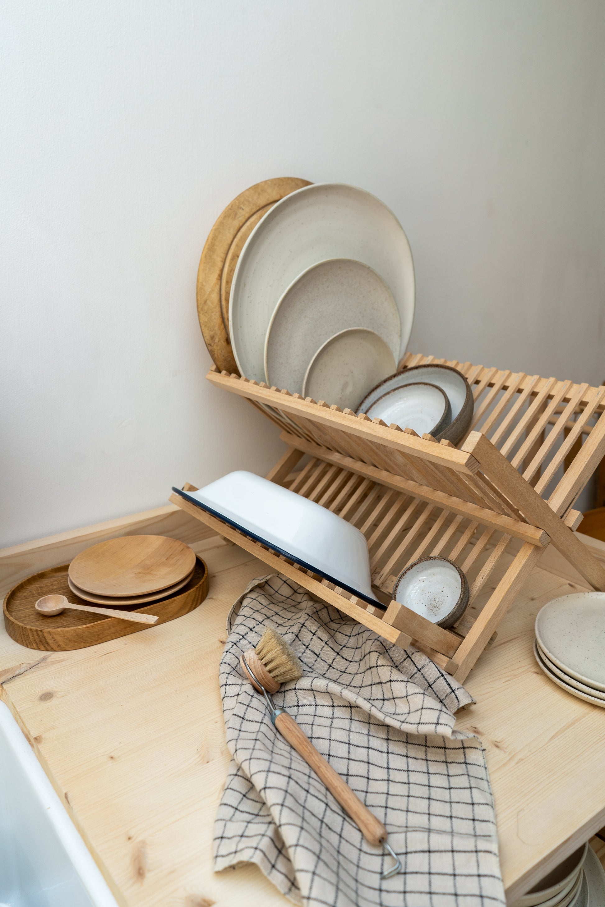 Wooden dish rack with plates and bowls on a kitchen counter.