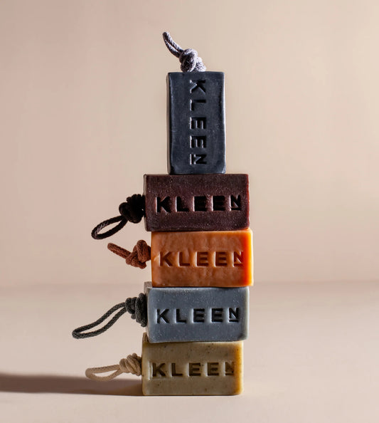 Stack of Kleen brand soap bars with visible branding on a beige background