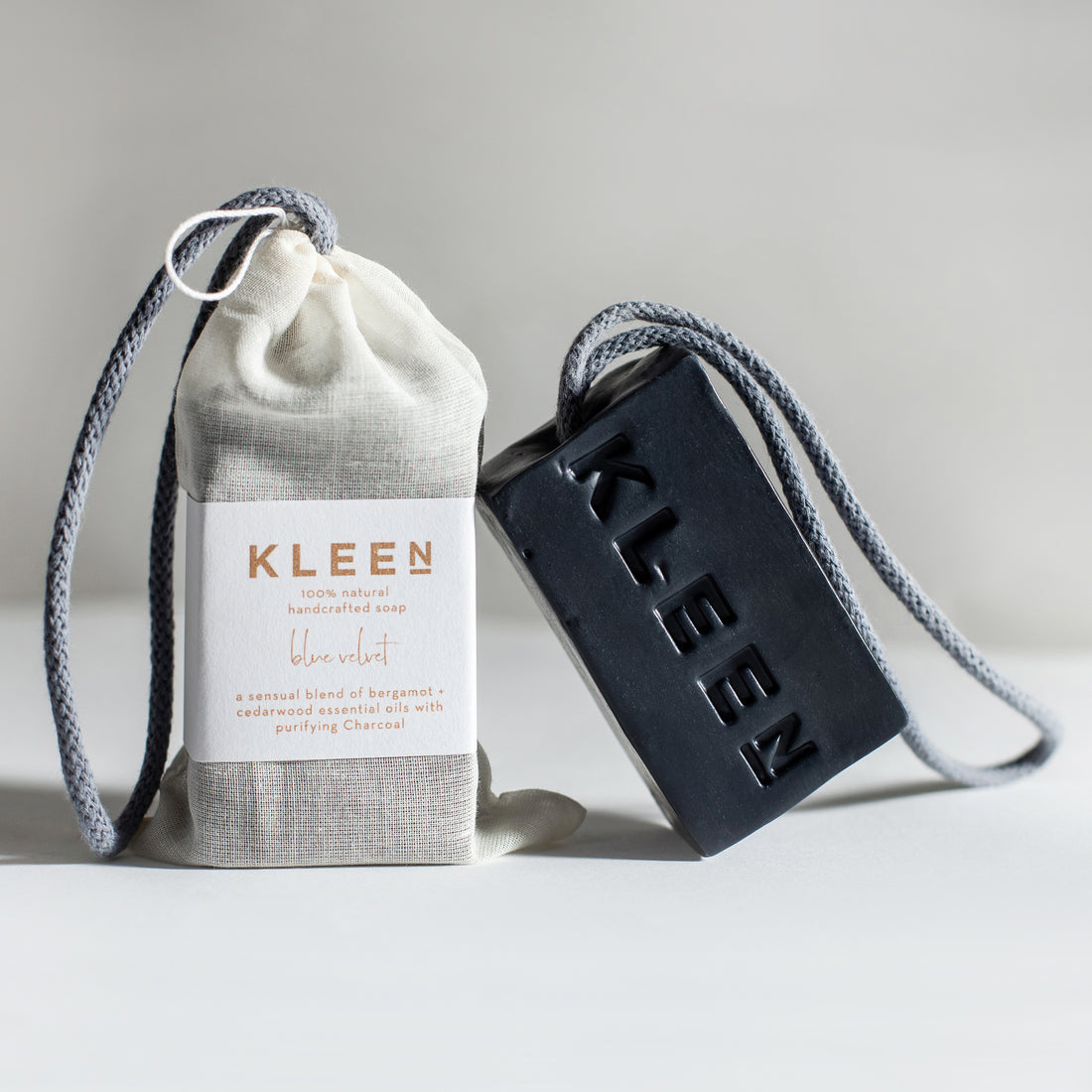 Kleen soap bar and drawstring bag on a light gray background