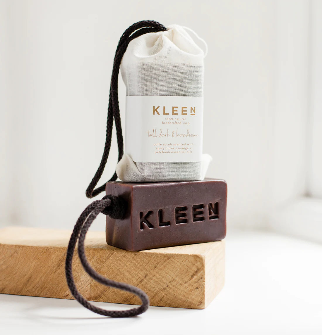 Kleen bar of soap and cloth on a wooden block with a white background
