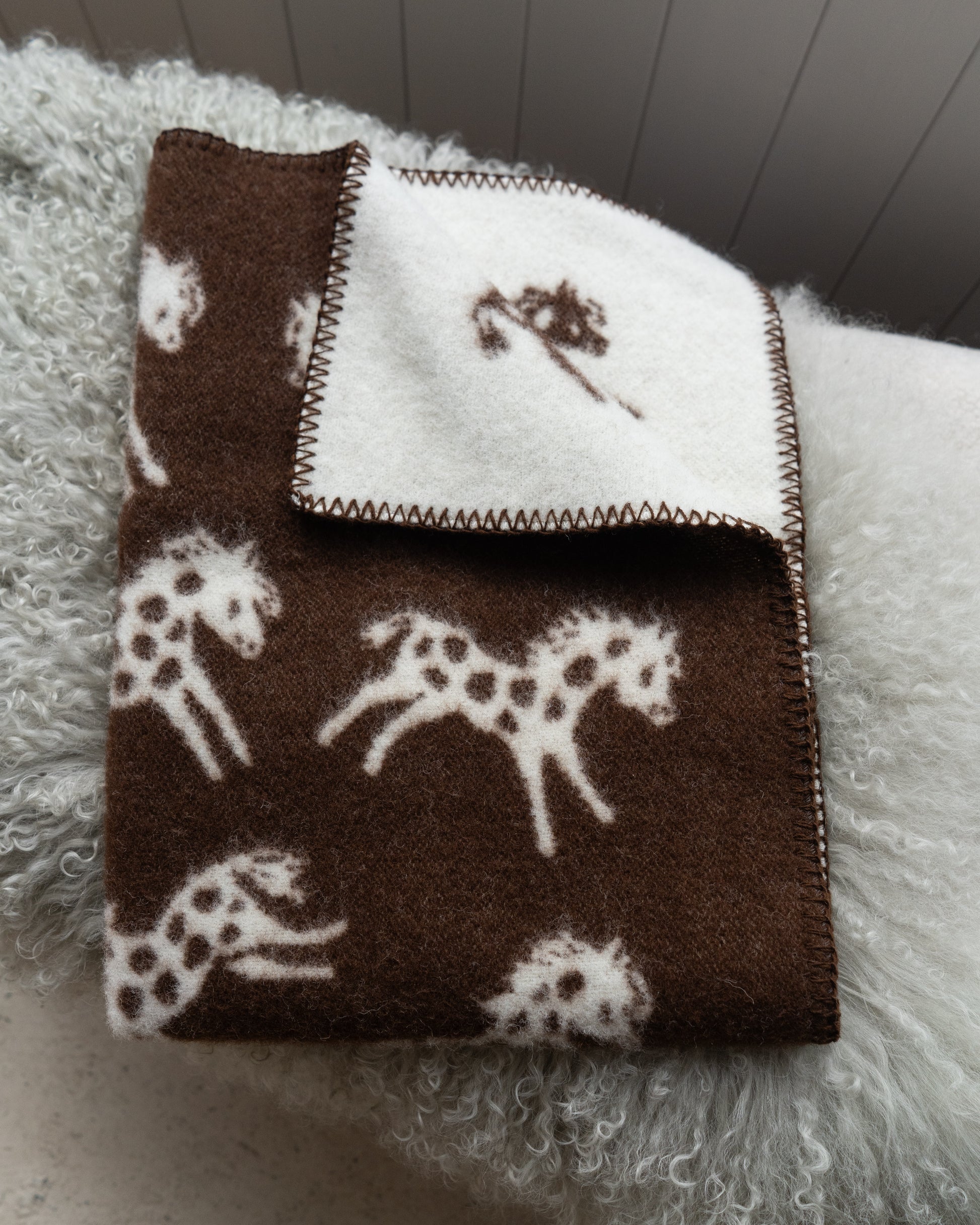 Blanket with horse pattern on a textured surface