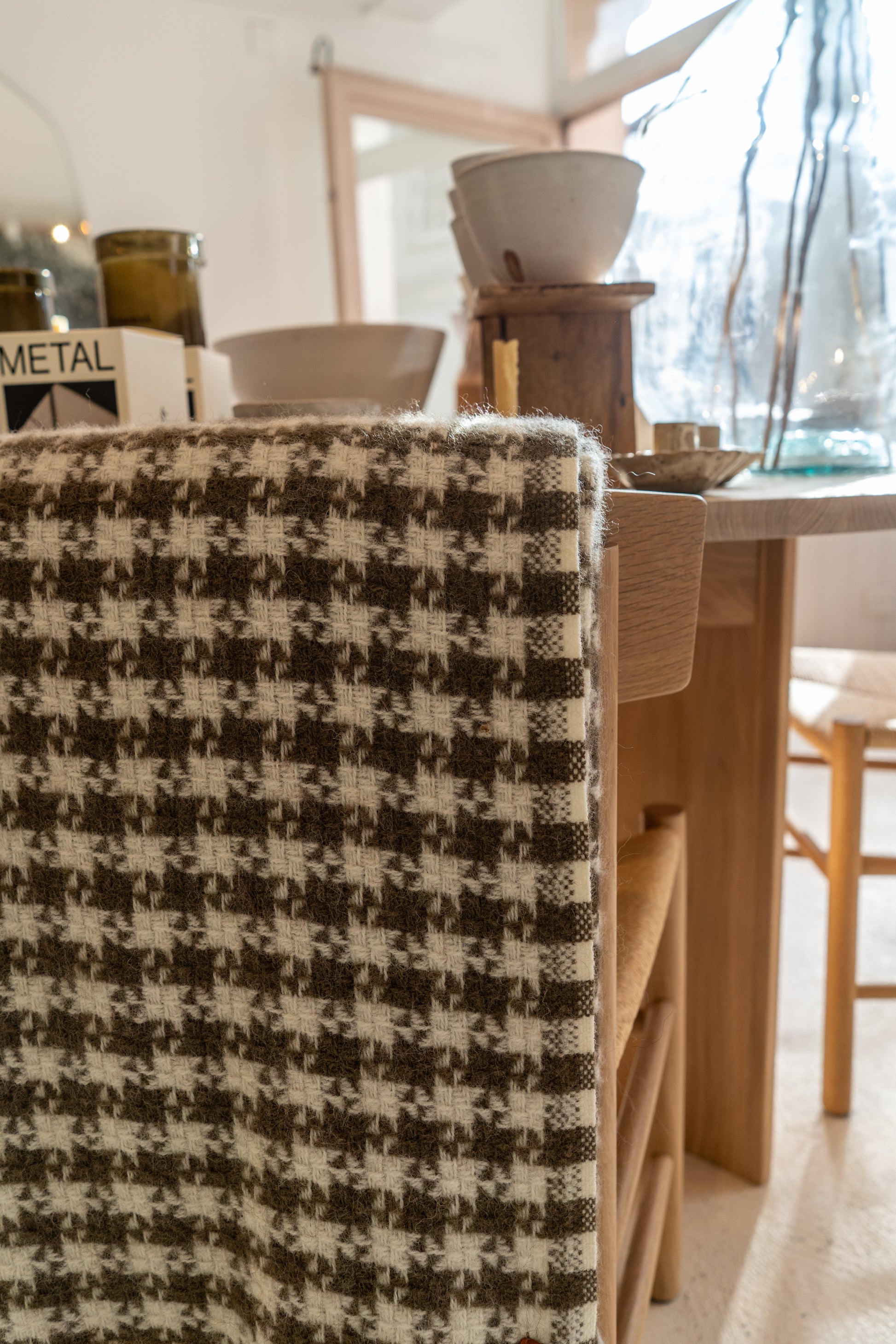Houndstooth patterned chair in a room with a wooden table and decor items.